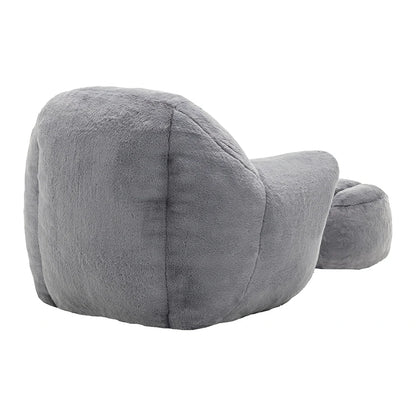 Back view of plush grey armchair with ottoman