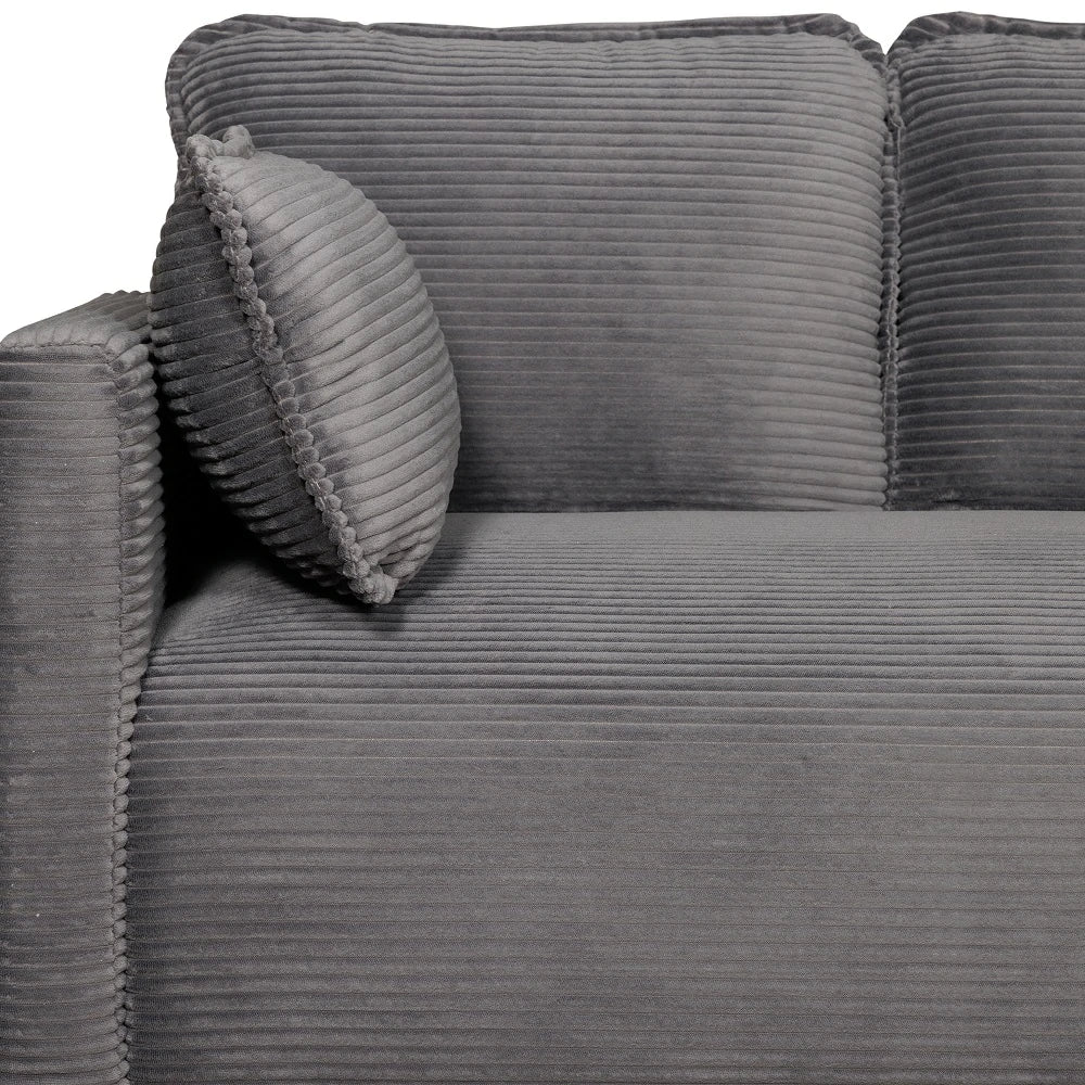 Close up of armrest and pillow on grey corduroy sofa