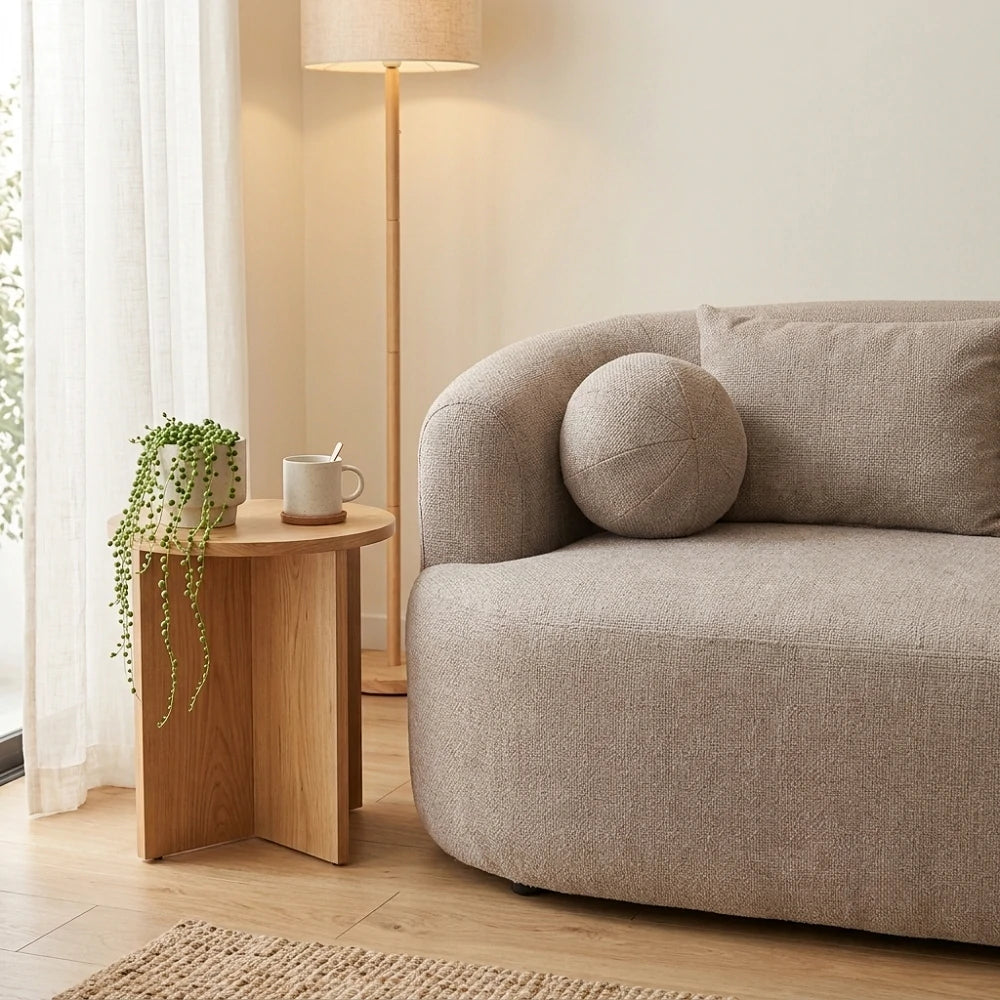 Close_up_of_round_throw_pillow_and_armrest_on_fabric_sofa