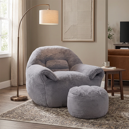 Plush grey armchair with matching ottoman in a modern living room