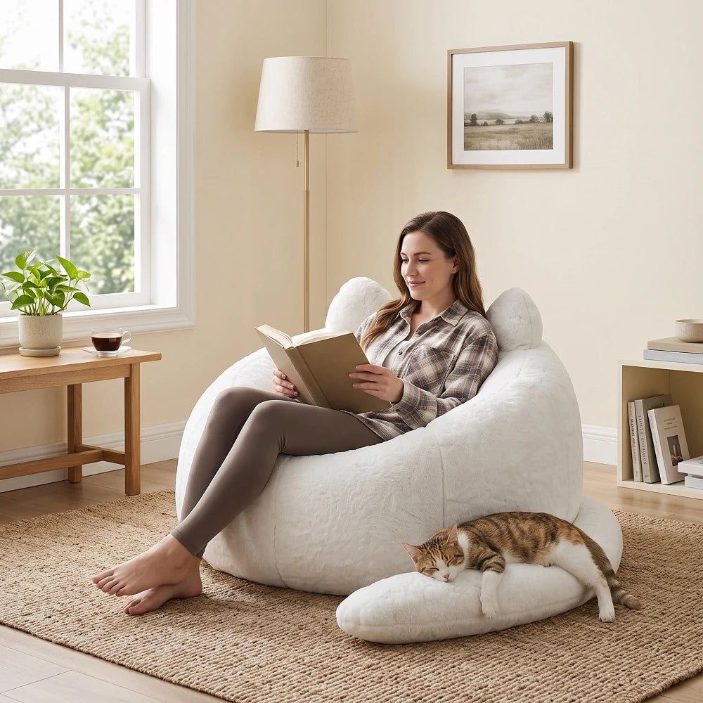 Woman sitting comfortably in a white faux fur cat bean bag chair reading a book